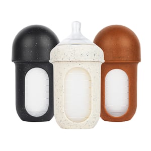 Boon Nursh silicone pouch baby bottles in black, speckled cream, and brown on white background