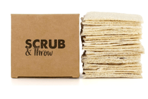 Scrub & Throw natural loofah scrub sponges, a stack of flat dried loofah pads beside a plain cardboard box